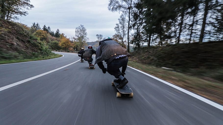 tres, persona, muntar a cavall, monopatins, costa avall, durant el dia, grup, gent, longboard, carretera, transport, a l'aire lliure, velocitat, dia, moviment, passeig, moviment borrós, persones reals, esport, activitat, homes, en moviment, casc, longitud completa, arbre, naturalesa, vista del darrere, 2K