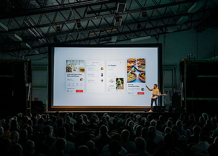 persoon, bespreken, staand, voorkant, groot, scherm, mensen, binnen, dim-verlichte kamer, man, presenteren, stadium, tonen, mannetje, menigte, gebouw, presentatie, conferentie, spreker, publiek, licht, donker, conf, echte mensen, groep mensen, binnenshuis, mannen, grote groep mensen, vrouw, volwassen, aan het kijken, op zoek, projectiescherm, technologie, levensstijlen, kunst cultuur en entertainment, zittend, architectuur, achteraanzicht, 2K, CC0, publiek domein, royaltyvrij