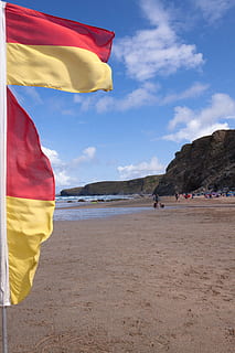 Flaggen, rot, Gelb, Abgrenzung, Surf-Bereich, Küste, Küstenwache, Rock, Meer, Wasser, Himmel, Landschaft, Strand, Natur, Wolken, See, felsige Küste, Klippen, Idylle, Spiegeln, atlantisch, Sandstrand, Flagge, Land, Sand, Patriotismus, wolke - himmel, Schönheit in der Natur, Tag, echte Menschen, zufällige Menschen, Szenen - Natur, Wind, Sonnenlicht, Nicht-städtische Szene, draußen, 4K, CC0, gemeinfrei, lizenzfrei