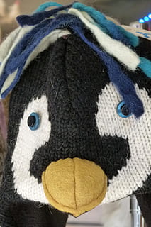 tuque, a maglia, divertente, berretto, lana, faccia di pinguino, avvicinamento, animale, nessuno, temi animali, pupazzo di pezza, giocattolo, rappresentazione, arte e artigianato, creatività, rappresentazione animale, uccello, tessile, giorno, inverno, blu, mestiere, carina, parte del corpo animale, in casa, 2K, CC0, dominio pubblico, privo di copyright