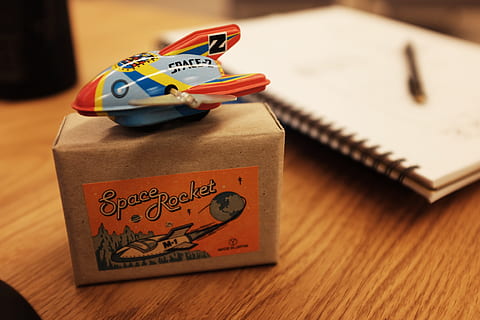 space rocket toy, Space Rocket, Toy, rocket, space, objects, no People, wood - Material, text, indoors, close-up, day, communication, focus on foreground, table, western script, publication, book, still life, high angle view, paper, non-western script, script, antique, education, selective focus, architecture, small group of objects, 4K