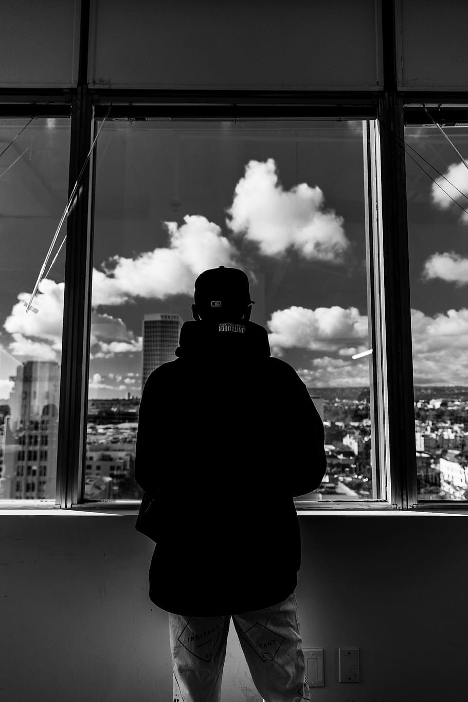 fotografie ve stupních šedi, muž, stojící, okno, nepojmenovaná, mrak, město, panoráma města, směrem ven, zpětný pohled, skutečných lidí, tři čtvrtletí, muži, průhledný, sklo - materiál, mrak - nebe, životního stylu, jedna osoba, volnočasové aktivity, den, nebe, uvnitř, silueta, při pohledu přes okno, architektura, Příroda, při pohledu na pohled, 5K