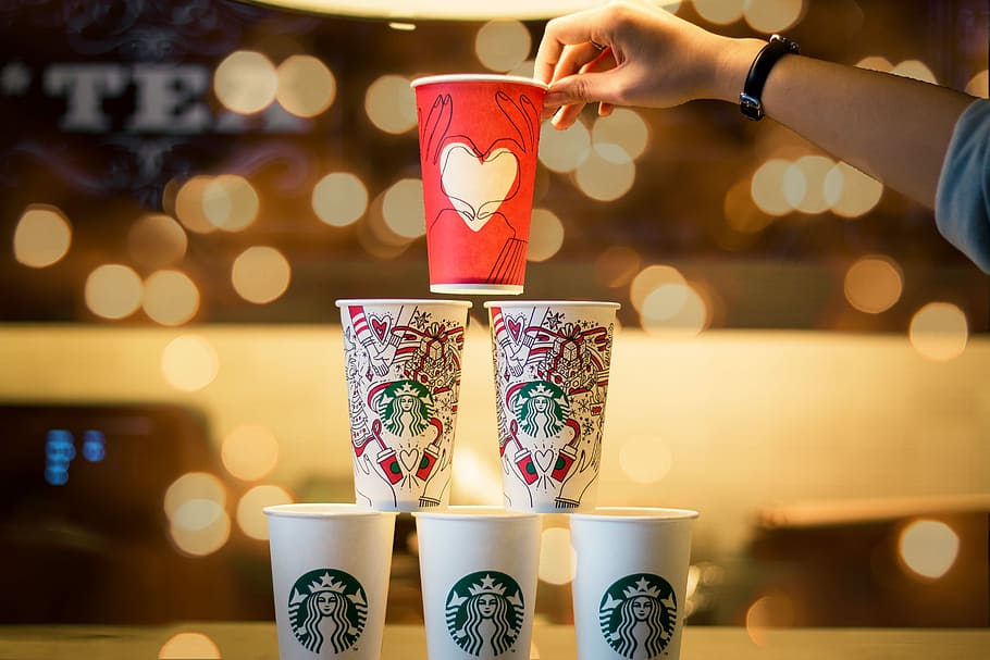 persona, apilament, cinc, tasses assortides de colors estrella, celebració, vermell, d'un sol ús, tapa, tassa, pila, starbucks, cafè, cafeteria, mà humana, mà, part del cos humà, beure, menjar i beguda, il·luminat, adult, una persona, estils de vida, a l'interior, refresc, dones, centrar-se en primer pla, vidre, dit, 5K