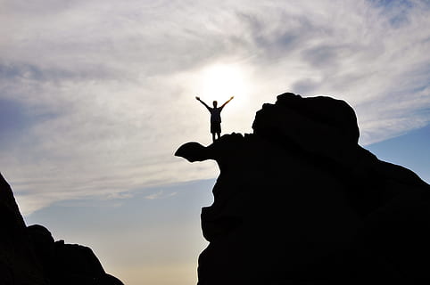 light, sky, man, person, backlit, clouds, outdoors, silhouette, cloud - sky, rock, solid, rock - object, lifestyles, leisure activity, one person, low angle view, nature, real people, men, human arm, rock formation, sunset, standing, arms raised, 4K, CC0, public domain, royalty free