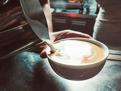 tassa de latte, cappuccino, cafè, llet, taula, preparació, menjar i beguda, cap gent, a l'interior, beure, primer pla, dia, beguda espumosa, frescor, estri de cuina, refresc, celebració, una persona, part del cos humà, mà humana, beguda calenta, mà, menjar, centrar-se en primer pla, cullera, utensili per menjar, adult, latte, preparar el menjar, vaixella, 2K, CC0, domini públic, lliure de regalies