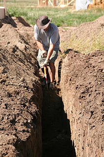 hombre cavando tierra, excavación, hombre, trabajo, trabajando, aguas residuales, plomería, pala, cavar, zanja, tubo, tendido, hombres, suciedad, trabajador manual, industria de construccion, al aire libre, sitio de construcción, gente, ocupación, una persona, gente real, longitud total, actividad de ocio, ropa casual, estilos de vida, naturaleza, día, rock, tierra, roca - objeto, sólido, esfuerzo, vista frontal, luz del sol, campo, pantalones cortos, 2K, CC0, dominio público, libre de derechos