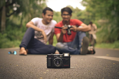 black, camera, front, two, men, sitting, road, analog camera, cycle, friends, friendship, green, indian, street, adult, young adult, young men, front view, camera - photographic equipment, casual clothing, photography themes, technology, retro styled, two people, focus on foreground, lifestyles, smiling, people, day, leisure activity, portrait, outdoors, photographer, couple - relationship, 5K, CC0, public domain, royalty free