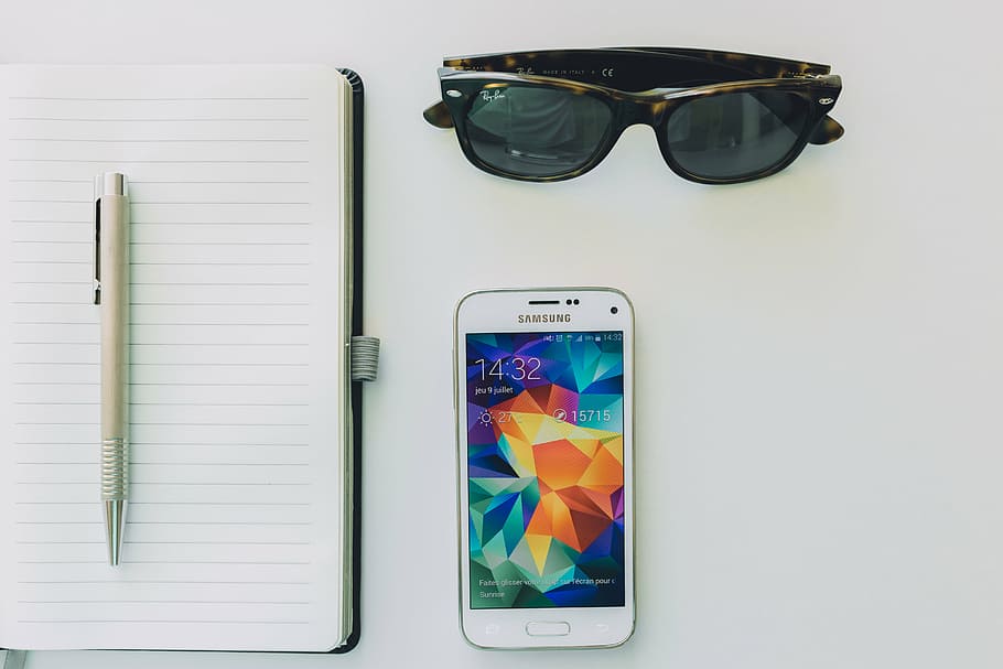 blanc, samsung android smartphone, folrat, paper, feu clic a ploma, superior, samsung, smartphone, mòbil, Bloc de notes, quadern, bolígraf, tecnologia, ulleres de sol, objectes, negocis, tecnologia sense fils, cap gent, a l'interior, dia, primer pla, gots, pantalla, dispositiu d’informació portàtil, telèfon intel·ligent, telèfon mòbil, comunicació, pantalla del dispositiu, connexió, natura morta, ulleres, directament a sobre, pantalla tàctil, moda, taula, accessori personal, 5K