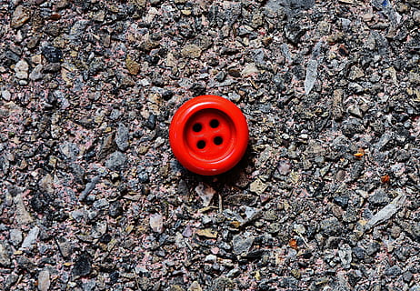 button, 4 holes, red, close, high angle view, day, no people, land, nature, field, safety, solid, outdoors, directly above, security, stone - object, gravel, protection, textured, rock, close-up, street, shape, 5K, CC0, public domain, royalty free