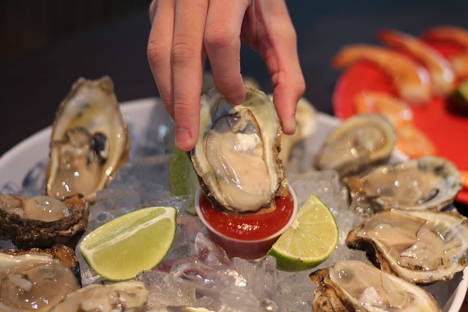 østers, halv shell, fisk og skaldyr, menneskelig hånd, mad og drikke, hånd, menneskelig kropsdel, mad, en person, frugt, indendørs, tæt på, friskhed, citrus frugt, sund kost, forberedelse, bedrift, citron, velvære, skive, finger, 4K