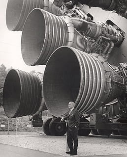 gråtonebilleder, mand, stående, metal maskine, dagtimerne, raketmotor, dyser, motor, raket, Flymotor, turbine, dr wernher von braun, 1969, saturn v s ic, sort og hvid, teknologi, luftfartsindustrien, NASA, rumrejse, rigtige mennesker, herrer, beskæftigelse, fuld længde, en person, dag, industri, fabrik, maskineri, arbejder, bagfra, metal, udendørs, ingeniørarbejde, udstyr, fremstilling, industrielt udstyr, 2K, CC0, offentligt domæne, royaltyfrie