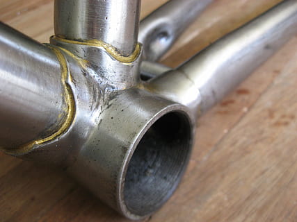 telaio della bicicletta, finitura grezza, movimento centrale, metallo, avvicinamento, nessuno, legno - materiale, in casa, color argento, singolo oggetto, vecchio, concentrarsi sulle conoscenze acquisite, vista dall'alto, acciaio, tavolo, legna, attrezzatura, lega, tubo - tubo, brillante, tubo, natura morta, 2K, CC0, dominio pubblico, privo di copyright