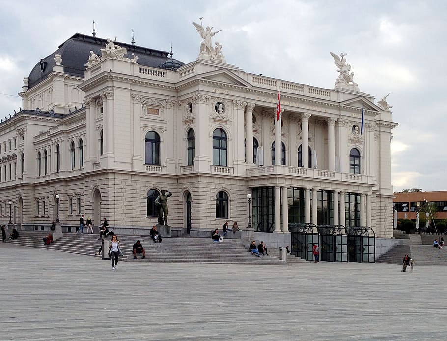 gent, referència, edifici, banderes, arquitectura, a l'aire lliure, escultures, estàtua, exterior de l'edifici, estructura construïda, ciutat, cel, grup de persones, gran grup de persones, destinacions de viatge, el passat, història, multitud, persones incidentals, núvol - cel, naturalesa, carrer, façana, persones reals, turisme, escultura, viatjar, ornamentat, columna arquitectònica, 2K