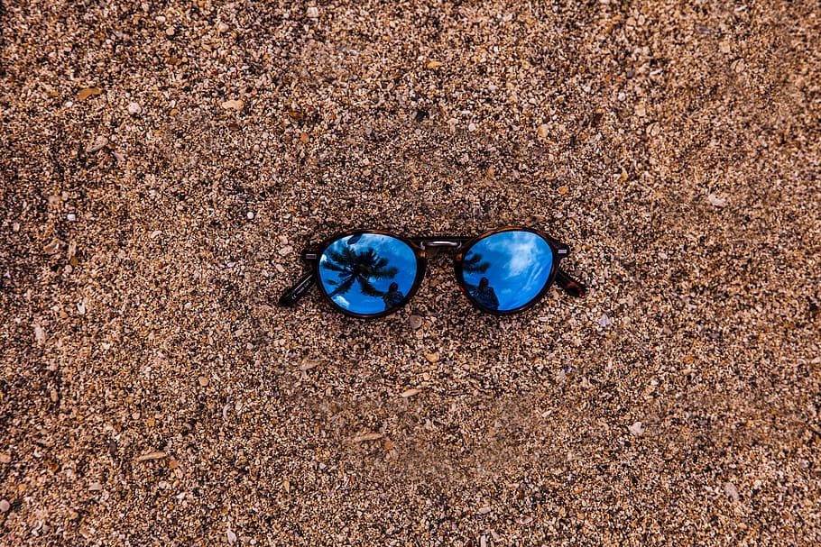 Foto, solbriller, jord, strand, afspejling, ru, muslingeskaller, kysten, nuancer, struktur, blå, dag, sko, sand, ingen mennesker, høj vinkel visning, natur, tæt på, direkte over, udendørs, sollys, stilleben, par, solid, tøffel, klippe, sten-, tekstureret, rullesten, personlige tilbehør, kompatibilitet, 2K