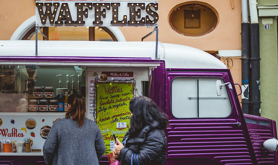 dos, dones, porpra, blanc, furgoneta de waffle, botiga, durant el dia, de peu, frontal, camió d'aliments per a gofres, furgoneta, vehicle, gofres, menjar, menjar de carrer, manera de transport, adult, transport, gent, dues persones, activitat d'oci, persones reals, assegut, roba casual, transport públic, ciutat, vista del darrere, viatjar, vehicle terrestre, dia, estils de vida, adult jove, comunicació, pentinat, roba calenta, 5K
