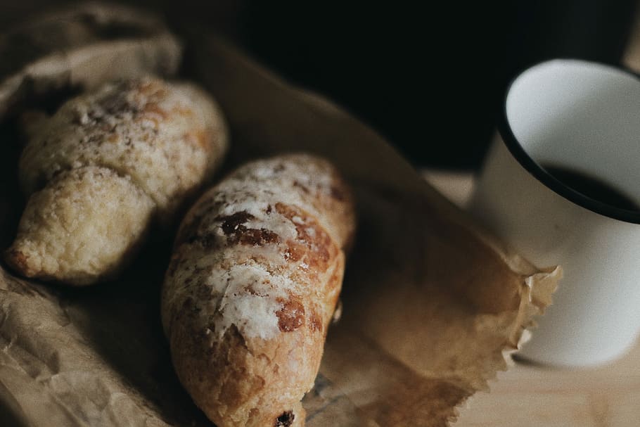 zwei, Brote, neben, Weiß, Tasse, Gebäck, Becher, Frühstück, Kaffee, Brot, Tabelle, Lebensmittel, Holz, Papiertüte, Morgen, Kaffeehaus, Kaffeepause, Essen und Trinken, Frische, Wohlbefinden, gesundes Essen, drinnen, keine Leute, Stillleben, Nahansicht, Fokus auf den Vordergrund, fertig für den Verzehr, selektiver Fokus, High Angle View, gebacken, Mahlzeit, hausgemacht, Getränk, Haushaltsausstattung, französisches Essen, 5K