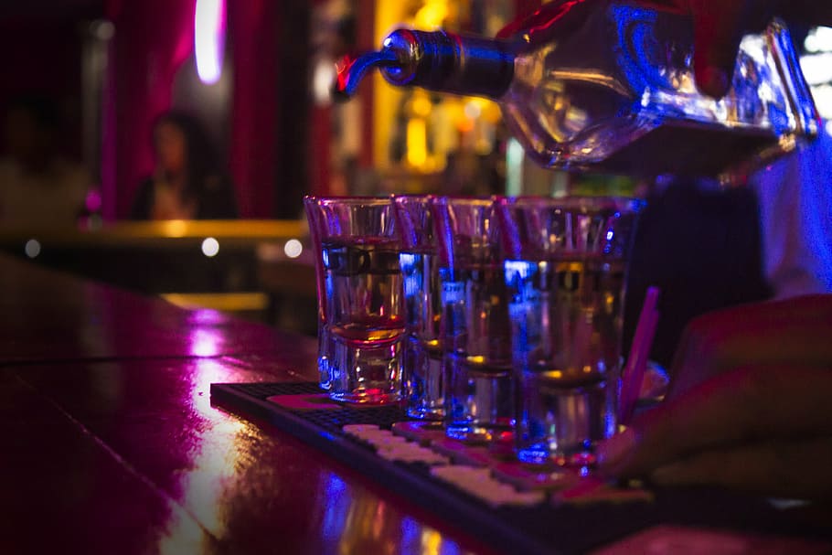 persona, abocament, licor, gots, tequila, barra, tasses, bar - establiment de begudes, alcohol, beure, refresc, comptador de barres, menjar i beguda, vidre, mà, nit, vida nocturna, a l'interior, mà humana, discoteca, copa, hora feliç, equipament per a la llar, copa de vidre, primer pla, part del cos humà, club d’animació, barman, còctel, clubbing, 4K