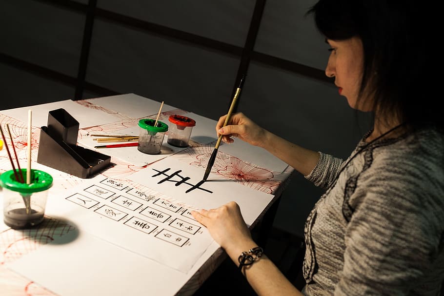 woman, holding, pen, writing, table, calligraphy, japan, character, creativity, concentration, one person, indoors, brush, paintbrush, paper, real people, text, art and craft, adult, young adult, skill, lifestyles, leisure activity, headshot, hairstyle, 1080P