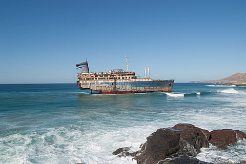 body of water, bay, beach, daylight, decayed, decaying, ocean, outdoors, rusty, sea, seascape, seashore, ship, water, watercraft, waves, sky, nautical vessel, land, clear sky, transportation, nature, architecture, day, mode of transportation, blue, no people, horizon over water, rock, shipwreck, scenics - nature, deterioration, ruined, 2K, CC0, public domain, royalty free
