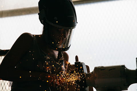 person, standing, beside, gray, bench grinder, using, welding, welder, sparks, machine, mask, one person, helmet, security, waist up, portrait, building exterior, headwear, safety, adult, architecture, headshot, lifestyles, nature, protection, real people, leisure activity, built structure, city, transportation, crash helmet, obscured face, 5K, CC0, public domain, royalty free