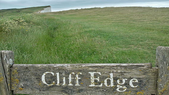 cliffs, demolition edge, risk, warning, crash, attention, caution, nature, text, wood - material, communication, grass, plant, western script, day, no people, land, field, tranquil scene, landscape, tranquility, sign, green color, fence, barrier, information, boundary, outdoors, 2K, CC0, public domain, royalty free