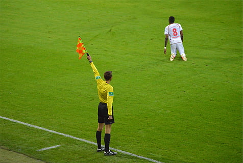 soccer referee, raising, yellow, flag, soccer, referee, holding, orange, stripe, field, sports, athlete, real people, green color, rear view, grass, men, playing, leisure activity, lifestyles, day, full length, group of people, sport, people, nature, togetherness, team sport, standing, plant, outdoors, uniform, 1080P, CC0, public domain, royalty free