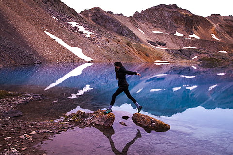 snow, landscape, mountains, nature, adventure, daylight, environment, exploring, high, hike, hiking, jump, motion, mountain peak, outdoors, person, reflections, rocks, scenic, water, woman, mountain, leisure activity, real people, lifestyles, full length, one person, reflection, scenics - nature, beauty in nature, day, rock, rock - object, solid, women, men, lake, human arm, 2K, CC0, public domain, royalty free