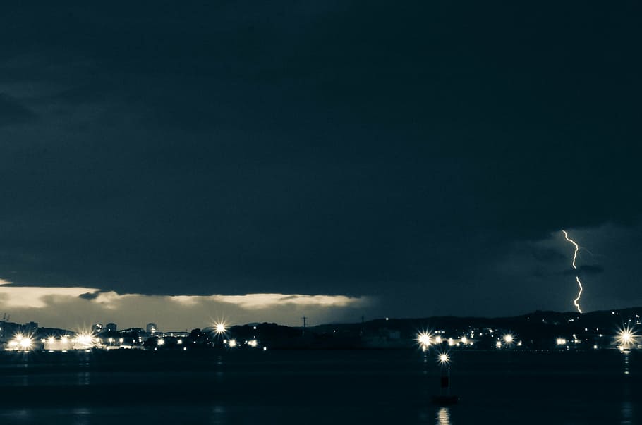 fotografia de timelapse, horitzó de la ciutat, tempestuós, temps, llamps, colpejar, nit, fosc, tempesta, núvols, llums, trons, fum - estructura física, Pol · lució, il·luminat, indústria, cel, cap gent, fums, estructura construïda, a l'aire lliure, núvol - cel, poder a la natura, arquitectura, poder, naturalesa, bellesa a la natura, ciutat, exterior de l'edifici, còpia espai, aigua, paisatge urbà, llum, ominós, 2K