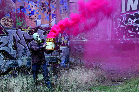 fluorescerende, mand, iført, gasmaske, bedrift, lyserød, røg, en person, graffiti, kreativitet, spraymaling, maling, rigtige mennesker, herrer, røg - fysisk struktur, fuld længde, stående, beskæftigelse, afslappet tøj, dag, skjult ansigt, tre kvart længde, lyserød farve, maske, Kunst og håndværk, sprøjtning, udendørs, rodet, 5K
