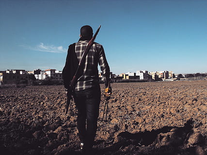man, black, plaid, dress shirt, arrows, bow, buildings, clouds, daylight, desert, farming, landscape, outdoors, person, sky, soil, town, walking, wear, one person, rear view, standing, real people, full length, architecture, nature, lifestyles, building exterior, land, men, casual clothing, leisure activity, sunlight, built structure, day, city, adult, 2K, CC0, public domain, royalty free