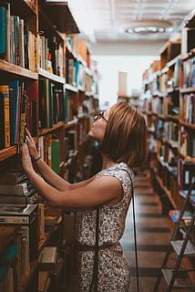 kvinne, stående, bibliotek bokhyller, iført, hvit, brun, floral, kjole, bokhylle, ser, mist deg selv, bibliotek, bok, utdanning, student, læring, innendørs, kvinner, universitet, kaukasisk etnisitet, hylle, hunner, lesning, studere, universitet student, litteratur, én person, forskning, mennesker, voksen, ung voksen, smilende, lærebok, unge kvinner, sidevisning, bare kvinner, ekte folk, utgivelse, frisyre, livsstil, uformelt antrekk, fritidsaktivitet, hår, profilvisning, 2K, CC0, offentlig domene, opphavsrett gratis