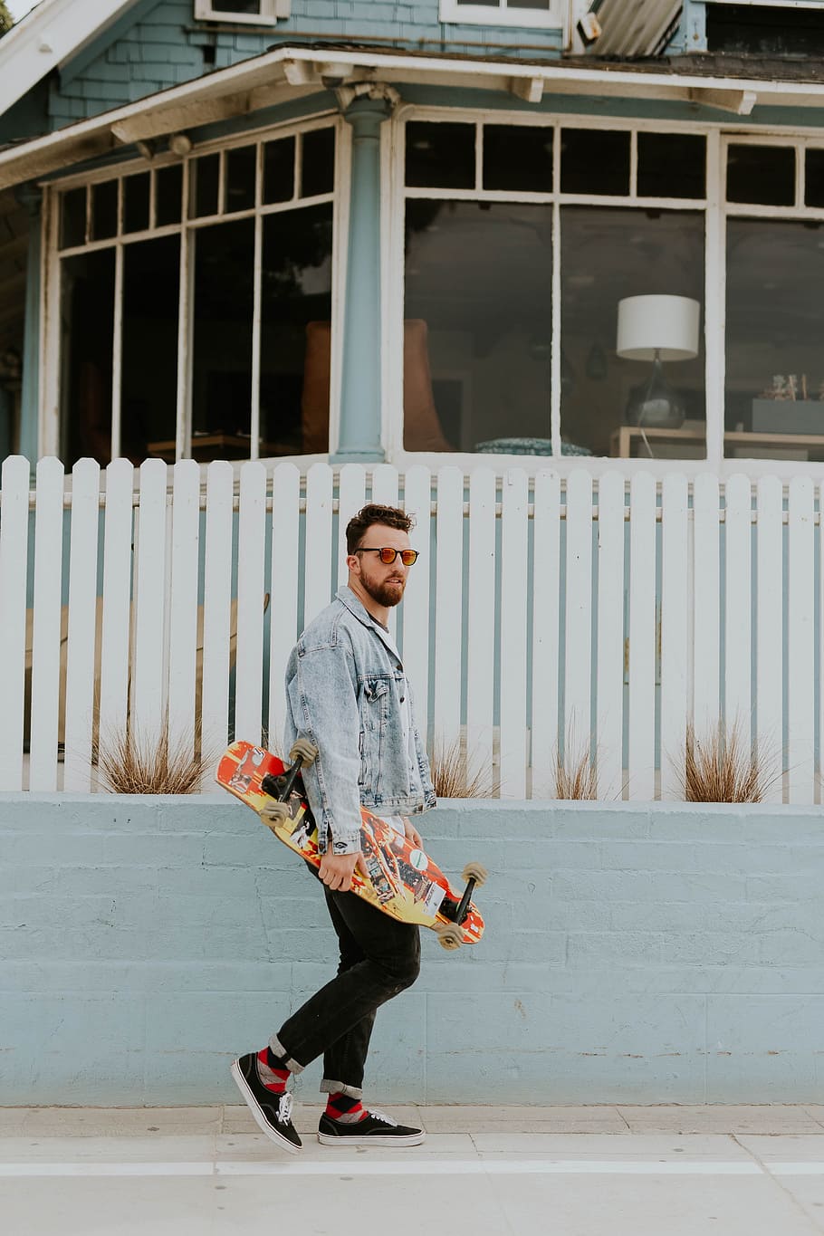 people, man, guy, walking, alone, play, skateboard, sport, wall, plant, fence, gate, outside, full length, one person, real people, looking at camera, architecture, young adult, portrait, built structure, lifestyles, standing, building exterior, young men, casual clothing, leisure activity, front view, day, outdoors, building, 5K