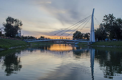 posta de sol, riu, platja, ciutat, taronja, embarcacions, cel del capvespre, paisatge, naturalesa, viatjar, silenci, tarda, reflexió, cel, núvols, sol, la ciutat, crepuscle, pont, vianants, moll, aigua, connexió, arquitectura, pont - estructura feta per l'home, estructura construïda, davant del mar, núvol - cel, transport, arbre, cap gent, planta, pont fixat per cable, exterior de l'edifici, a l'aire lliure, 4K, CC0, domini públic, lliure de regalies