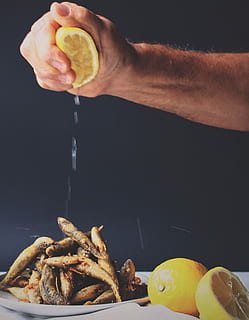 person, klemning, citron, stegt, fisk, mad, menneskelig hånd, friskhed, gourmet, bedrift, tæt på, menneskelig kropsdel, frugt, mad og drikke, sund kost, hånd, en person, citrus frugt, indendørs, velvære, rigtige mennesker, klar til at spise, livsstil, herrer, forberedelse, snack, sort baggrund, finger, orange, forbereder mad, 2K, CC0, offentligt domæne, royaltyfrie