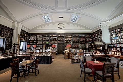 library at 1:20, library, interior, architecture, building, infrastructure, tables, chairs, knowledge, research, gallery, clock, chair, table, indoors, book, no people, bookshelf, day, seat, shelf, publication, built structure, furniture, business, restaurant, retail, lighting equipment, absence, bar - drink establishment, cafe, ceiling, electric lamp, bar counter, 8K