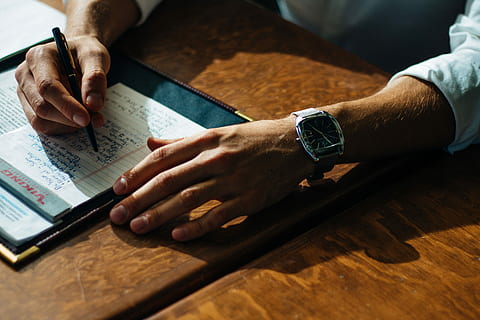 person, writing, paper, leaning, brown, table, ruled, hand, notes, notebooks, shadow, human hand, human body part, wireless technology, technology, indoors, communication, time, men, adult, wristwatch, one person, watch, connection, business, finance, close-up, touch screen, 5K, CC0, public domain, royalty free