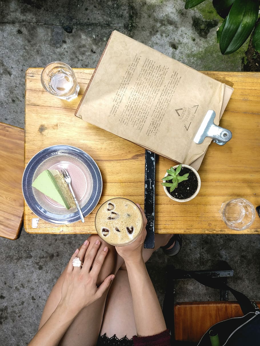 iced, coffee, matcha cake, Iced coffee, matcha, cake, dessert, drink, drinking, espresso, hands, top view, wood, wood - Material, table, one woman only, one person, only women, adults only, directly above, high angle view, human hand, human body part, food and drink, holding, real people, hand, indoors, food, lifestyles, adult, leisure activity, publication, body part, book, refreshment, glass, preparing food, 4K