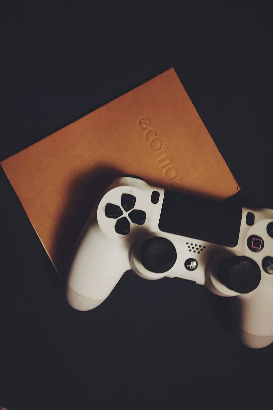 quadern, modern, analògic, controlador, botons, controlador de jocs, gamepad, joypad, playstation, a l'interior, tir de l'estudi, fons negre, cultura i entreteniment artístic, natura morta, primer pla, cap gent, vista d’angle alt, jocs d’oci, daus, joc, taula, oportunitat, sort, grup d'objectes, color negre, activitat d'oci, còpia espai, paper, directament a sobre, 4K