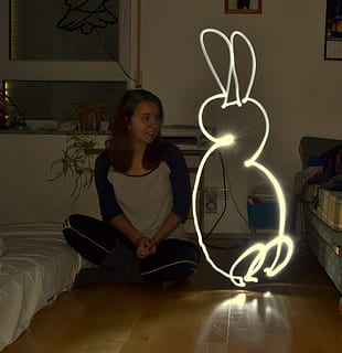 lightpainting, hare, light, one person, real people, illuminated, casual clothing, indoors, lifestyles, front view, glowing, sitting, leisure activity, home interior, communication, light painting, domestic room, lighting equipment, standing, emotion, night, young adult, teenager, 1080P, CC0, public domain, royalty free