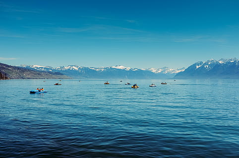 group, people, swimming, beach, board, body, water, paddle boats, pedal boats, lake, blue, sky, sunshine, mountains, snow, peaks, landscape, outdoors, nature, beauty in nature, sea, scenics, waterfront, tranquility, tranquil scene, mountain, scenics - nature, transportation, cold temperature, travel, mountain range, day, winter, nautical vessel, floating on water, 4K