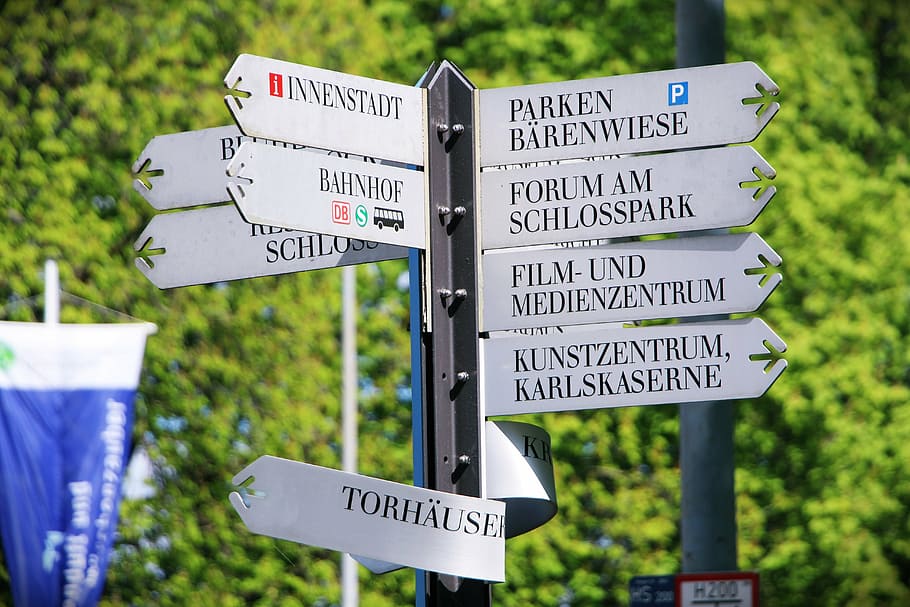 senyalització de carreteres, escut, navegació, directori, direcció, navegar, orientació, orientar, classificació, al sud, a l'est, oest, carrera, professional, ludwigsburg germany, llocs d'interès, indecisos, fletxes, cercar un lloc al parc, aconsella, signe, senyal de trànsit, guió occidental, text, comunicació, senyal direccional, cap gent, centrar-se en primer pla, planta, informació, símbol, carretera, dia, signe d'informació, símbol de fletxa, arbre, naturalesa, a l'aire lliure, missatge, senyal de creuament, 5K