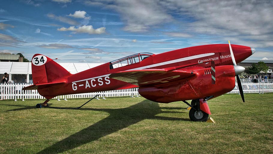 de, havilland dh .88 comet, dh.88, vermell, pla g-acss, herba, avió, avions, camp, vehicle aeri, cel, naturalesa, transport, manera de transport, cap gent, aeroport, planta, dia, núvol - cel, pista d’aeroport, llum solar, a l'aire lliure, terra, arquitectura, 5K