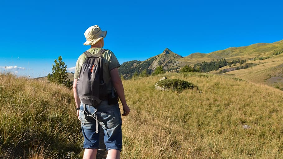 pausa, parada, ruta, senderisme, mirar a la distància, calma, serenitat, creuar, senyal, interrupció, trencar, muntanya, mercat, estiu, una persona, vista del darrere, motxilla, roba casual, tres quarts de longitud, activitat d'oci, cel, herba, barret, viatjar, vacances, naturalesa, viatge, aventura, activitat, roba, adult, festa, mirant la vista, a l'aire lliure, 4K