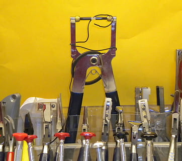 hulpmiddelen, optisch, tang, uitrusting, instrument, professioneel, laboratorium, meting, optometrist, opticien, oog, bril, gezichtsvermogen, lens, gezondheidszorg, visie, montuur, geel, gele achtergrond, geen mensen, binnenshuis, dag, metaal, variatie, keuze, handgereedschap, gereedschap, machinerie, werktuig, detailopname, grote groep objecten, muur - bouwfunctie, stilleven, muziek-, onderdeel van de machine, opknoping, in een rij, industrie, staal, legering, agressie, 2K, CC0, publiek domein, royaltyvrij