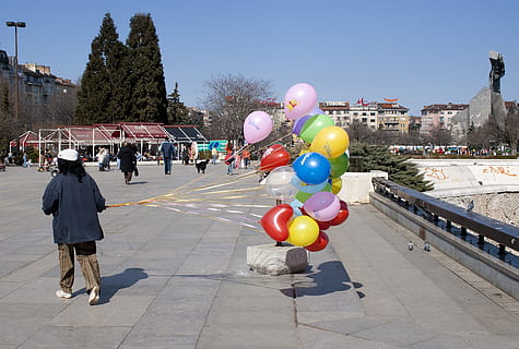 Sofia, Luftballons, Wind, Ballon, Straße, Stadt, die Architektur, Gebäudehülle, Tag, gebaute Struktur, Baum, Natur, Frau, Heliumballon, Stadt leben, mehrfarbig, Feier, zufällige Menschen, in voller Länge, draußen, Erwachsene, echte Menschen, Fußweg, 2K, CC0, gemeinfrei, lizenzfrei