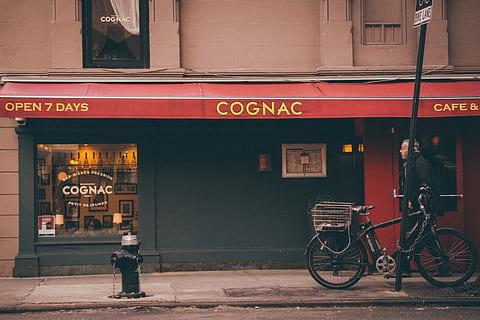 Mann, Gehen, Vorderseite, Cognac-Laden, Cognac Store Fassade, schwarz, Fahrrad, Cafe, Bar, Restaurant, Fenster, Straße, Transport, Stadt, die Architektur, Kommunikation, Text, Gebäudehülle, Transportmittel, westliche Schrift, Zeichen, Reise, Stadt leben, gebaute Struktur, Landfahrzeug, Fußweg, draußen, zufällige Menschen, Bürgersteig, Menschen, 5K, CC0, gemeinfrei, lizenzfrei