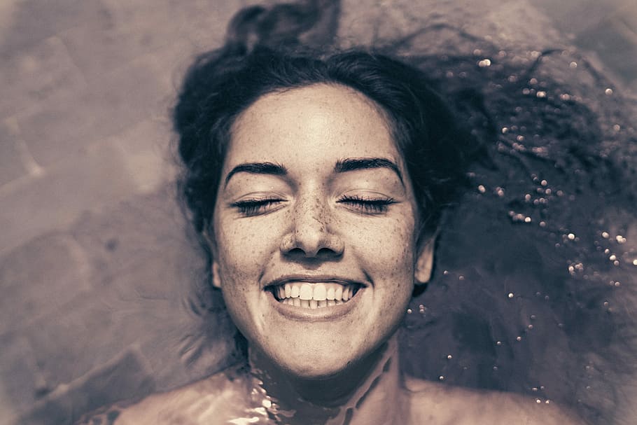 kvinde, smilende, badning, flydende, vand, ansigt, portræt, pool, svømmepøl, hovedskud, lukkede øjne, lykke, en person, ung voksen, menneskelig kropsdel, emotion, hår, lempelse, menneskeligt ansigt, voksen, kropsdel, skønhed, høj vinkel visning, tæt på, direkte over, udendørs, mudder, smuk kvinde, frisure, 8K