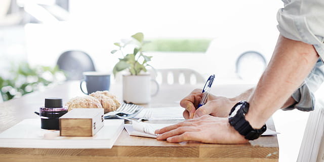persona, escritura, mesa, libro, un pan, brillante, bollo, café, casual, silla, de cerca, vaso, día, comedor, documento, equipo, mano, información, masculino, hombre, jarra, naturaleza, objetos, papeleo, bolígrafo, árbol, de madera, adentro, Sólo para adultos, parte del cuerpo humano, adulto, gente, adulto joven, dos personas, tecnología inalámbrica, mano humana, hombres, comida y bebida, beber, machos, negocio, mueble, vida domestica, taza de café, vajilla, 4K, CC0, dominio público, libre de derechos