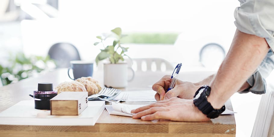 persona, escriure, taula, llibre, pa, brillant, bun, cafeteria, casual, cadira, primer pla, tassa, dia, taula de menjador, document, equipament, mà, informació, masculí, home, naturalesa, objectes, paperassa, bolígraf, arbre, fusta, a l'interior, només adults, part del cos humà, adult, gent, adult jove, dues persones, tecnologia sense fils, mà humana, homes, menjar i beguda, beure, mascles, negocis, mobles, la vida domèstica, tassa de cafè, vaixella, 4K