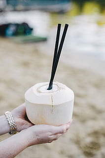 holding, fresh, coconut, Female, summer, fruit, holidays, vacations, fresh coconut, coconut water, juice, straw, coconut milk, beach, human Hand, outdoors, sand, sea, nature, food, human body part, focus on foreground, one person, hand, real people, close-up, body part, drinking straw, day, unrecognizable person, food and drink, lifestyles, refreshment, women, indulgence, disposable, finger, nail, human limb, temptation, 2K